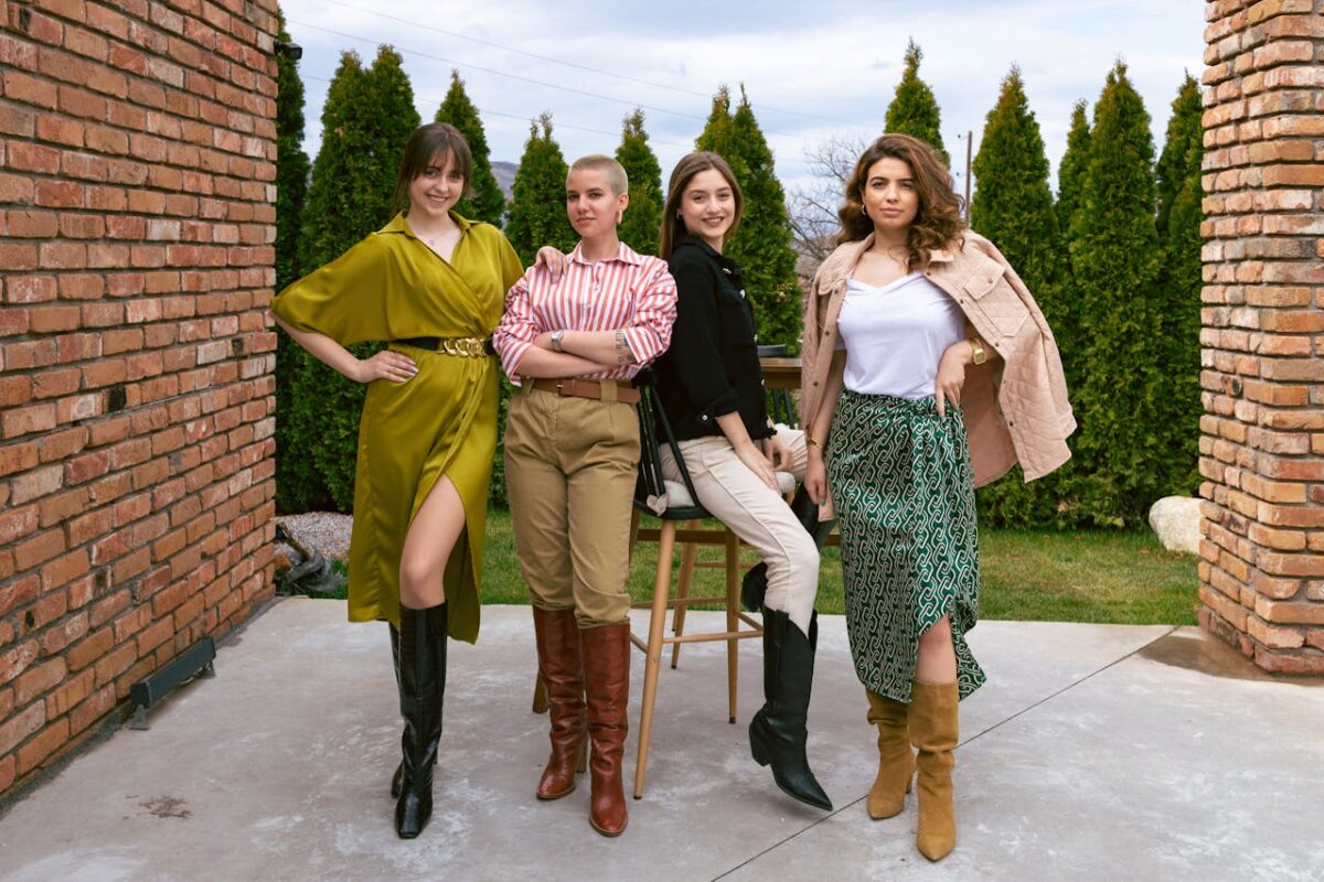 Four women showcasing unique outfits and boots, posing confidently outdoors.