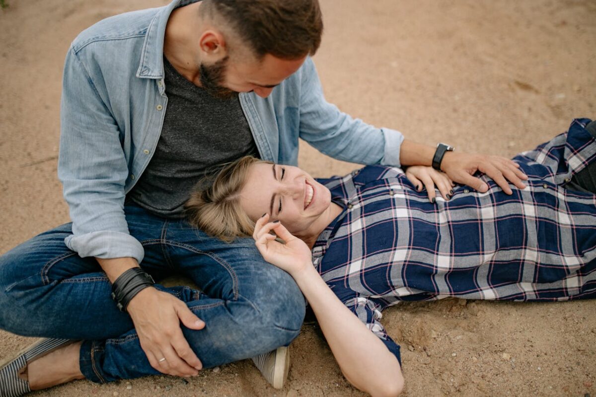 A joyful couple enjoying a relaxed moment on a sandy beach.